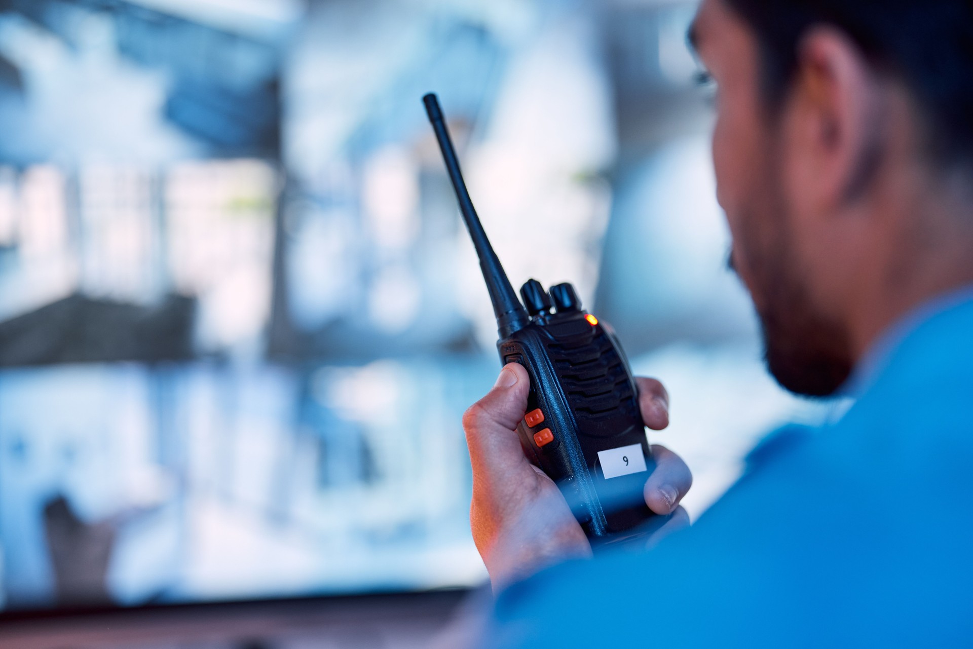 Security guard, radio and cctv monitor, communication and inspection service for building safety. Screen, video surveillance agency and law officer in control room talking on two way intercom system.