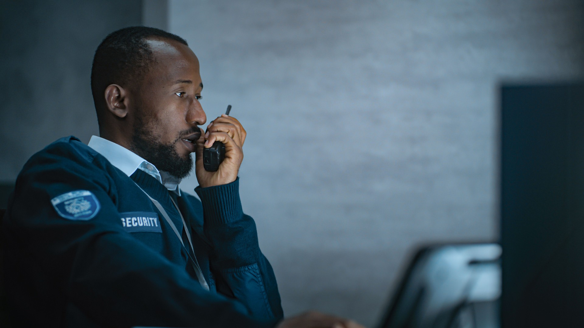 African American security officer works in monitoring center during night shift